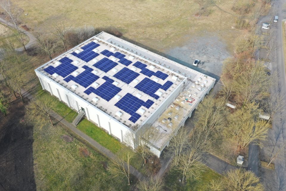 Sporthalle Bettenhausen mit Solaranlagen auf dem Dach, umweltfreundliche Energiequelle.