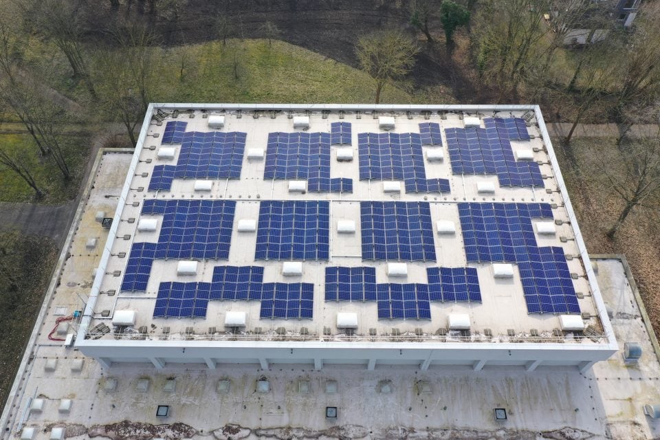 Dach der Sporthalle Bettenhausen mit installierten Solarmodulen für nachhaltige Energie.