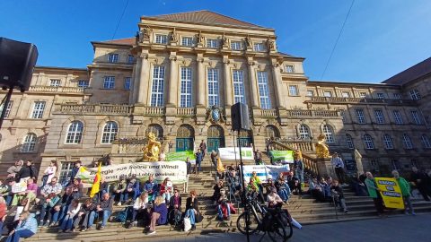 Menschen versammeln sich vor dem Kasseler Rathaus bei einer Demonstration.